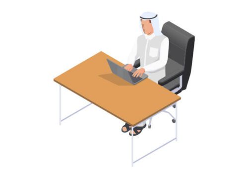مدير بزي سعودي يجلس على كرسي أسود وأمامه طاولة خشبية عليها حاسوبه.